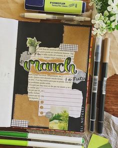 an open notebook with writing on it next to some markers and pens, including one green marker