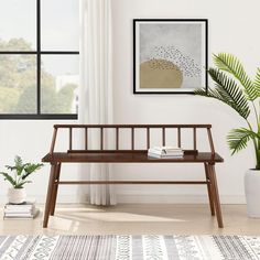 a wooden bench sitting in front of a window next to a potted palm tree