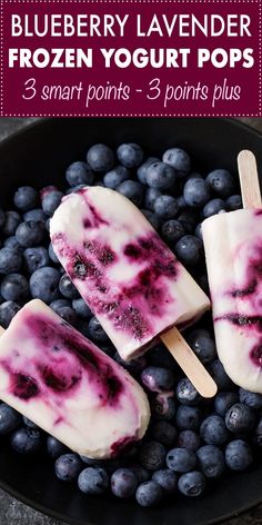 blueberry lavender frozen yogurt pops in a black bowl with fresh blueberries