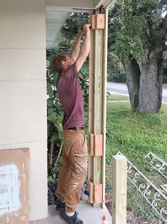 a man working on the side of a house