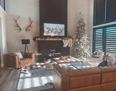 a living room filled with furniture and a fire place in front of a christmas tree