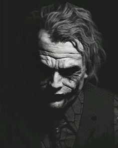 the dark knight joker in black and white, with his face painted like an evil man