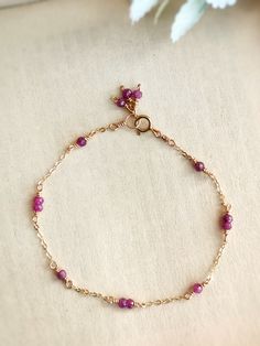 This dainty bracelet is handmade with tiny genuine ruby beads in 14K Gold Filled, Rose Gold Filled, or Sterling Silver. It is hypoallergenic and nickel-free.The delicate chain is made with a 1-2-1 stone pattern and ends with a cute cluster of 3 stones for decoration.• Gemstone size: 2-3 mm• Made with natural, genuine ruby beads📏 To find your bracelet size, measure your wrist and add 0.5 - 1 inch for room to wiggle, depending on your personal preference. For example, if your wrist is 6 inches, y Pearl Bracelet Dainty, Delicate Charm Bracelet, Dainty Handmade Jewelry, Dainty Accessories, Beads Craft Jewelry, Pearl Jewelry Design, Ruby Bracelet, Diy Jewelry Inspiration, Ruby Beads