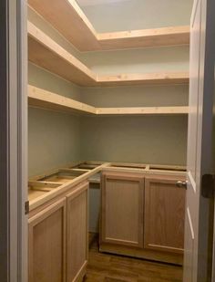 an empty pantry with wooden cabinets and no one in the room to be used for storage