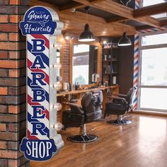 a barber shop sign hanging from the side of a brick wall next to a chair