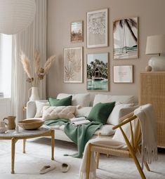 a living room filled with white furniture and pictures on the wall above it's coffee table