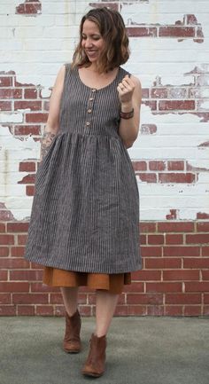 a woman standing in front of a brick wall