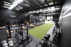 an indoor gym with rows of exercise equipment and green carpeted area for people to use