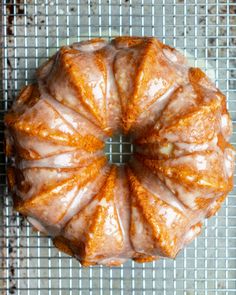 a bundt cake sitting on top of a cooling rack covered in frosted icing