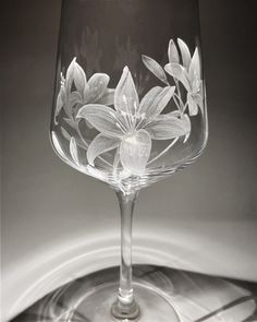 a wine glass with flowers etched on it