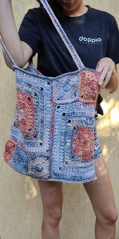 a woman holding onto a crocheted purse