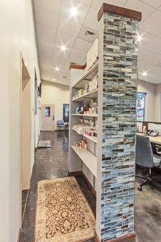 an office with shelves and rugs on the floor