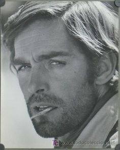 a black and white photo of a man with long hair