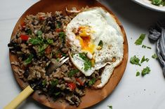 an egg and rice dish on a wooden plate