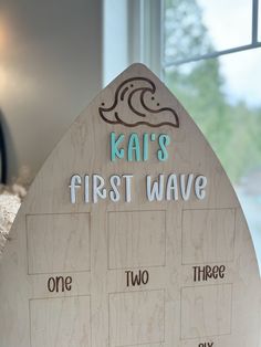 a wooden sign that says ka's first wave and two other words on it