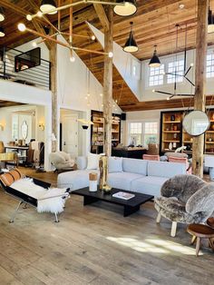 a living room filled with lots of furniture next to a wooden floor covered in windows