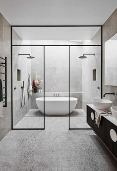 a white bath tub sitting inside of a bathroom next to a walk in shower stall