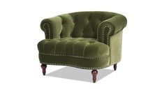 a green velvet chair with studded trimmings on the arms and back, against a white background