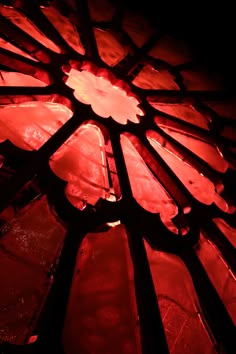 a stained glass window with red light shining through it