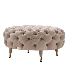 a round ottoman with gold legs and tufted upholstered design on the top