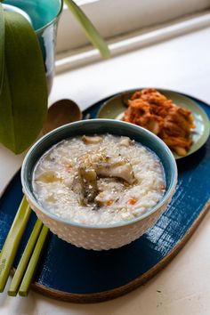 a bowl of food on a blue plate with chopsticks and a flower pot