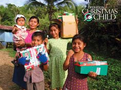 children holding presents in their hands and smiling for the camera