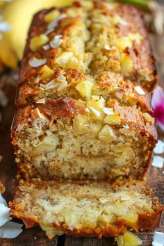 a loaf of banana nut bread on a wooden cutting board with bananas in the background