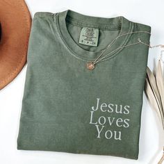 These soft and thick Comfort Colors shirts are embroidered with "Jesus Loves You" * 100% ring-spun cotton * Fabric weight: 6.1 oz/yd² (206.8 g/m²) * Garment-dyed * Relaxed fit * 7/8″ double-needle topstitched collar * Twill-taped neck and shoulders for extra durability * Double-needle armhole, sleeve, and bottom hems SIZING:  They're unisex but fit true to size (or very close to) for ladies. We recommend sizing up though if you prefer a roomier or oversized look! Guys, we definitely suggest sizi Christian Tshirts Design, Jesus Merch Aesthetic, Basic Christan Shirts, Christian Fits, T Shirt Jesus Christ, Jesus Loves You Shirt, Worship Outfits, Jesus Shirts Christian Clothing Elevated Faith, Jesus Loves You Tee Shirt