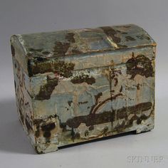 an old painted box sitting on top of a table