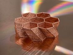 a small wooden object sitting on top of a metal surface with a rainbow in the background