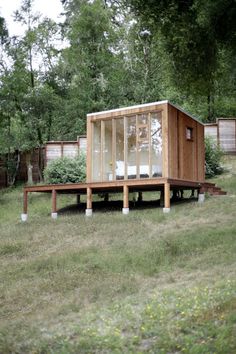 a small wooden structure sitting on top of a lush green field