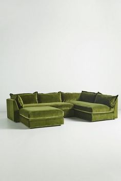 a large green couch sitting on top of a white floor