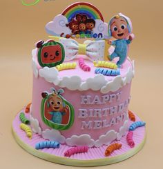 a pink birthday cake with cartoon characters on it