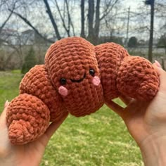 a hand holding a small crocheted stuffed animal