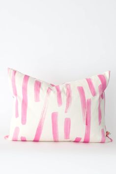 a pink and white pillow on a white background