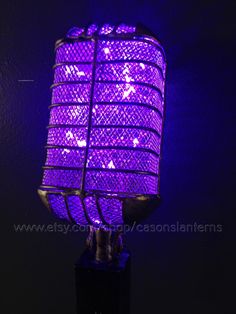 a purple lamp is lit up in the dark