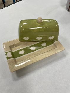 two green and white plates with hearts on them sitting on a table next to each other