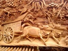 an intricately carved wooden panel depicting a man on a horse drawn carriage