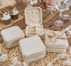 three personalized jewelry boxes sitting on top of a table next to cupcakes