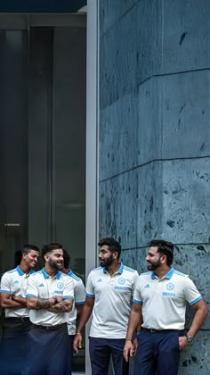 three men standing next to each other in front of a building