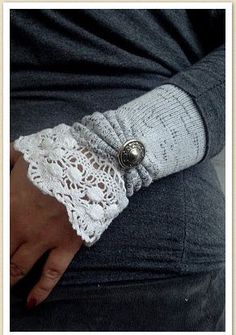 a close up of a person's arm wearing a lace cuff with a button on it