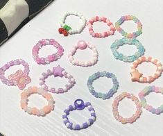 several bracelets are arranged on a table with beads and charms around them, including a pacifier