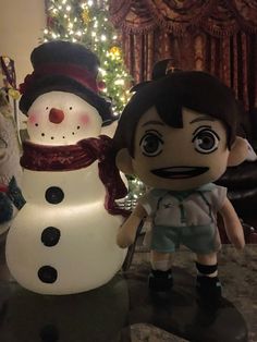 a snowman and a girl are standing next to each other in front of a christmas tree