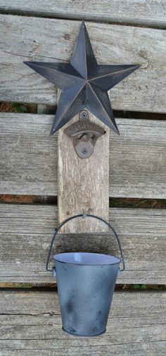 a metal bucket with a star hanging from it's side on a wooden wall