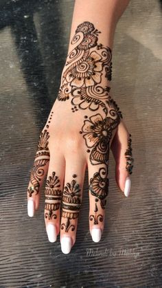 a woman's hand with henna tattoos on it