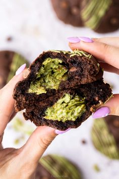 two hands holding an open chocolate avocado cookie