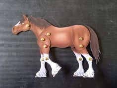 a brown and white horse standing on top of a black surface