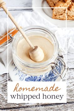 homemade whipped honey in a glass jar with a wooden spoon next to it on a white and blue plate