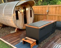 a hot tub sitting on top of a wooden deck next to a barrel shaped sauna