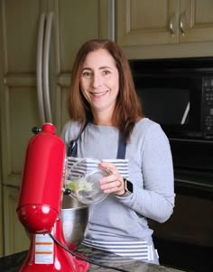 a woman standing in front of a red mixer